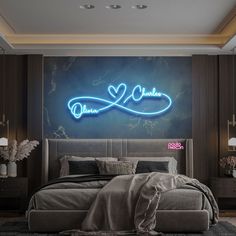 a bedroom with a large bed in front of a wall that has a neon sign above it