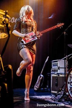 a woman with an electric guitar on stage