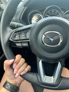 a woman holding the steering wheel of a car