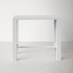 a white table sitting on top of a cement floor