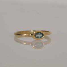 "This is a 18k gold Beautiful ring with a gentle oval blue Aquamarine gemstone. That soliter ring is just the perfect stacking ring. Not too big and not too small. You can wear this ring every day and for every occasion. The light blue Aquamarine color is a perfect harmony with the 18k solid gold. This ring can be the center piece of a set of gold stacking rings. I can set different gemstone in this gold ring. Dimensions: Oval Sapphire: 5 m\"m * 3 m\"m You can see other gemstone rings in my shop Timeless Oval Cabochon Sapphire Ring Gift, Oval Sapphire Emerald Ring As Birthstone, Oval Sapphire Ring With Polished Finish In 14k Gold, Oval Sapphire Ring In 14k Gold With Polished Finish, Modern Oval Emerald Ring In Yellow Gold, Yellow Gold Oval Emerald Birthstone Ring, Oval Yellow Gold Emerald Ring As Birthstone, Timeless Oval Sapphire Birthstone Ring, Oval Yellow Gold Emerald Ring With Birthstone