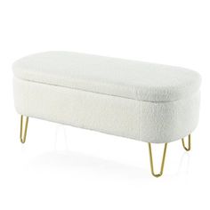 an upholstered white bench with gold legs