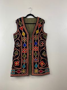 Made in Afghanistan, a rare find vintage sleeveless waistcoat. Hand embroidery on velvet. A very antique piece in mint condition.  Size: Male Medium Female Large Please contact for exact measurements. Note: Worn and minor signs of wear. Embroidered Festival Vest, Embroidered Sleeveless Vest For Festival, Festive Bohemian Vest With Intricate Embroidery, Vintage Embroidered Fitted Vest, Fitted Vintage Vest With Embroidery, Festive Sleeveless Vest With Multicolor Embroidery, Vintage Fitted Embroidered Vest, Traditional Vest With Floral Embroidery For Festival, Bohemian Embroidered Festival Vest