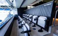 rows of white chairs sitting in front of a wall