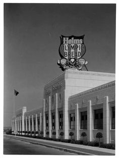 an old black and white photo of a building with a sign for hems olympic bread