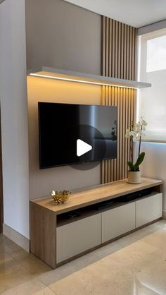 a flat screen tv sitting on top of a wooden entertainment center in a living room