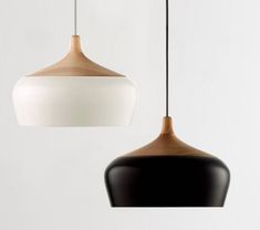 two hanging lights in different shapes and sizes, one white and the other black with wood accents