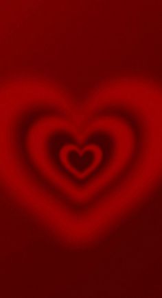 a red heart shaped object on a black background