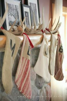 stockings hung on a mantle with deer antlers hanging from it's sides and pictures above them