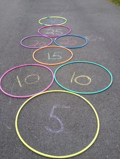 a row of colored circles with numbers painted on them sitting in the middle of a road