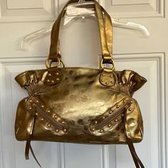 Nwot Gold Color With Brown Lining And Snap Closures. Has Gathering Effect On Each Side. Nice Large Size Bag. It Has A Sheer Similar To A Foil Look. 2 Zipper Small Pockets On Front With Tassels. Gold Tone Hardware. See Photos For Approximate Measurements And Also The Last Photo Shows Several Tiny Spots. I’m Not Sure If In The What It Is. I Saw One On The Other Side. It’s Not Noticeable But I Wanted To Point This Out. Smoke And Pet Free Home. Gold Satchel With Metal Hardware For Shopping, Gold Satchel With Metal Hardware In Tote Shape, Gold Satchel With Metal Hardware For Travel, Gold Satchel With Metal Hardware And Double Handle, Gold Shoulder Bag With Metal Hardware For Daily Use, Gold Satchel Tote With Metal Hardware, Gold Double Handle Shoulder Bag For Errands, Gold Shoulder Bag With Double Handle And Metal Hardware, Gold Handheld Shoulder Bag With Metal Hardware