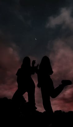 two people standing on top of a hill under a night sky with stars and clouds