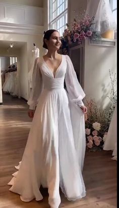 a woman in a wedding dress standing next to flowers