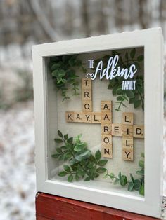 a cross made out of scrabbles is displayed in a shadow box