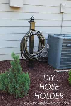 an air conditioner sitting next to a house with the words diy hose holder on it