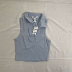 Rsq Women’s Sleeveless Polo Shirt . - Ribbed Construction - Fitted Top - Crop Top - Machine Wash Trendy Sleeveless Blue Vest, Trendy Blue Sleeveless Vest, Trendy Blue Tank Vest, Trendy Cropped Blue Vest, Trendy Blue Vest Top, Stretch Light Blue Sleeveless Top, Light Blue Stretch Sleeveless Top, Fitted Sleeveless Casual Top, Casual Fitted Sleeveless Tops