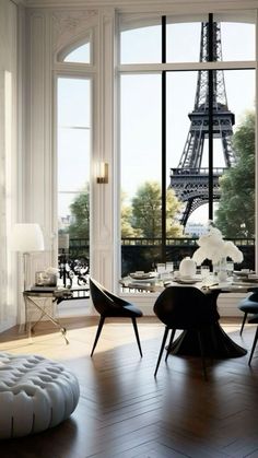 a living room filled with furniture and a large window overlooking the eiffel tower