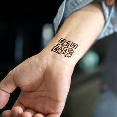 a person's arm with a small tattoo that has a qr code on it