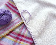 a purple ball of yarn sitting on top of a piece of cloth