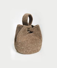 a straw bag on a white background with the handle extended to it's side