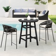 an outdoor table and chairs next to a pool