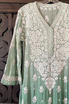 This Ombre Green Lucknowi Chikankari Muslin Kaj Patti Frill Kurti is a staple for any wardrobe. Crafted from Muslin Silk, this piece offers a stylish, elegant look with a frill design detail on the neck and sleeves. A-Line Muslin silk Length 45" inches Long sleeves 18" inches V neck Chikankari embroidery Hand embroidered Dry Clean Phulkari Pants, Lehenga Green, Lucknowi Kurta, Chikankari Lehenga, Ombre Green, Chikankari Embroidery, Trendy Outfits Indian, Lucknowi Chikankari, Embroidered Motifs