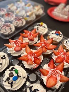 cupcakes with white frosting and decorated strawberries