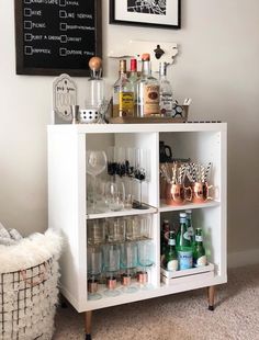 a white cabinet filled with liquor bottles and glasses