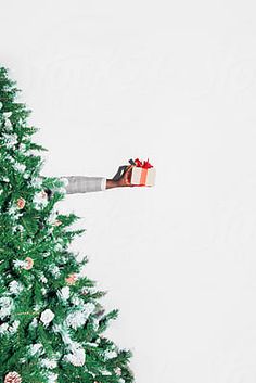 a christmas tree with presents on it in front of a white wall