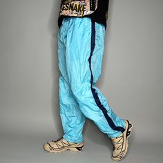 Vintage Track Pants Light Blue Nylon Baggy Fit Lined has Ankle Zippers to Flare Y2K Skate / Streetwear Great Condition: 9/10 Men's Size: Large My Hands in Pockets = It has Pockets No Hands in Pockets = Does Not Have Pockets Drawstring Will be Visible in Forward Pic, if not Visible it Does Not Have a Drawstring About me: I am 6' 0" for reference I generally wear a Large (32" inseam) I Model XS to 2XL sweatpants, I find that you can often size up or down with 95% of sweatpants and they fit the same Blue Nylon Long Pants, Blue Parachute Pants With Pockets For Outdoor, Casual Blue Parachute Pants For Outdoor, Blue Nylon Pants For Spring, Blue Nylon Parachute Pants For Sports, Sporty Blue Nylon Pants, Casual Blue Bottoms For Outdoor Activities, Urban Style Blue Long Pants, Spring Blue Athletic Pants