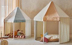 two children's play tents sitting on the floor next to each other in a room