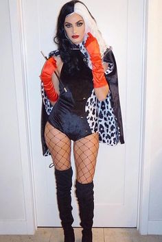 a woman dressed up in a costume standing next to a door with her hands on her hips