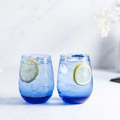 two blue glasses with lemon slices and water