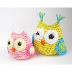 two crocheted owls sitting next to each other on top of a white surface