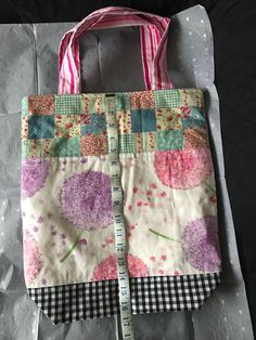 a pink and white bag sitting on top of a piece of paper with a ruler in it