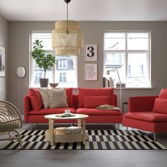 a living room filled with red couches and chairs