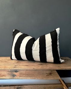 two black and white striped pillows on a wooden bench