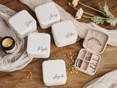 four personalized wedding rings and ring boxes on a table