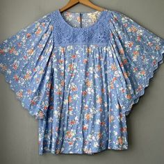 Matilda Jane Blue With Multi-Color Floral Rayon Popover Flutter Sleeve Peasant Top New With Tags! *Labeled Size Large. Please Pay Attention To Measurements As Sizes And Brands Vary. Bust - Measures 21 3/4" Across The Front From Armpit To Armpit Length - 25" Measured From Top Of Shoulder *Comes From A Smoke And Pet Free Home! Cottagecore Flowers Feminine Romcom Feminine Blue Flutter Sleeve Top, Feminine Blue Top With Flutter Sleeves, Bohemian Butterfly Sleeve Spring Blouse, Spring Bohemian Blouse With Butterfly Sleeves, Blue Cotton Blouse With Lace Trim, Blue Tops With Lace Trim For Vacation, Bohemian Tops With Floral Print And Butterfly Sleeves, Bohemian Floral Print Tops With Butterfly Sleeves, Spring Blue Butterfly Sleeve Blouse