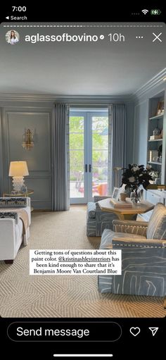 a living room filled with furniture and a door leading to another room that has french doors