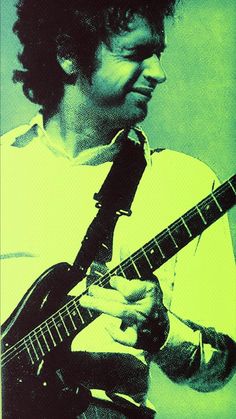 a man playing an electric guitar in front of a green background