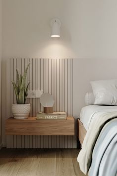 a bed room with a neatly made bed and a plant on the nightstand next to it