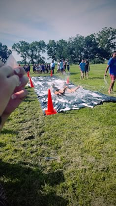 a person holding a cell phone taking a picture of a man laying on the ground