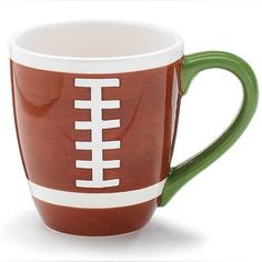 a green and white coffee cup with a football painted on the side is sitting in front of a white background