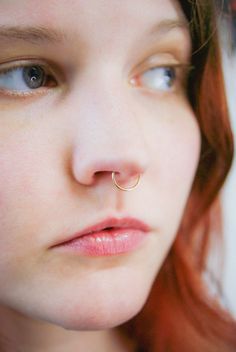 a close up of a person with a nose ring