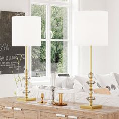 a living room with two lamps on the table and a chalkboard in the window