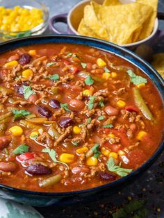 a bowl of chili with corn and tortilla chips