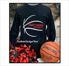 a black long sleeved shirt with red and white streamers next to a basketball