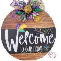 a welcome sign with mardi gras decorations on it's side and the words welcome to our home