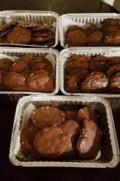 four pans filled with chocolate covered cookies on top of a table